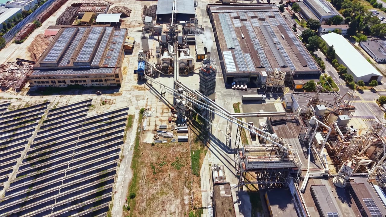 Area industriale che mostra fabbriche e pannelli solari con attrezzature viste dall'alto.