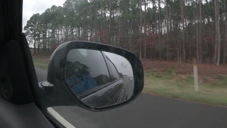 driving along a highway - passenger point of view out the side window to include the rear view mirror