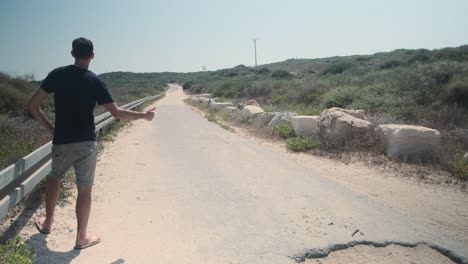 Lonely-Hitchhiker-man-trying-to-catch-a-ride-home-on-hot-road