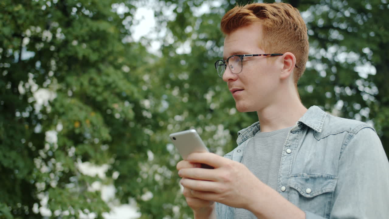 Young man using a smartphone in a park