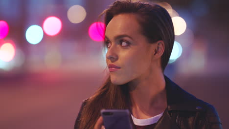 una mujer joven en la ciudad por la noche usando