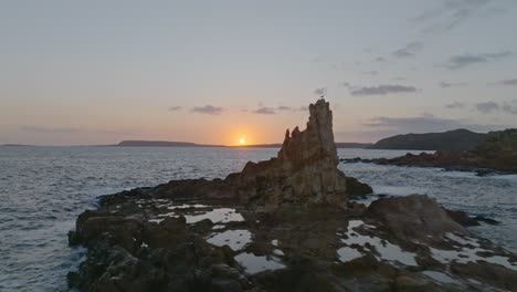 a sunset flyby of a solitary rocky formation near cala pregonda beach