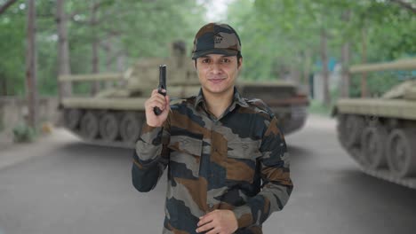 hombre del ejército indio posando con una pistola