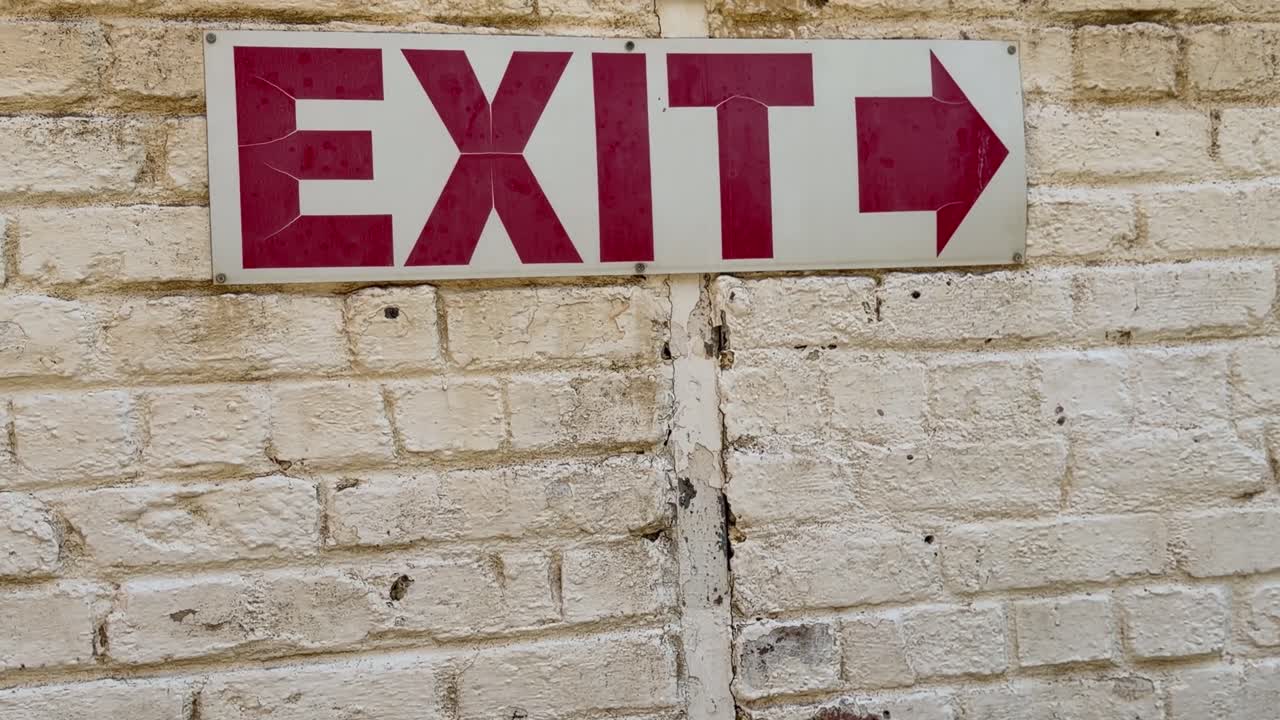 Un cartello "Uscita" su un edificio logoro.