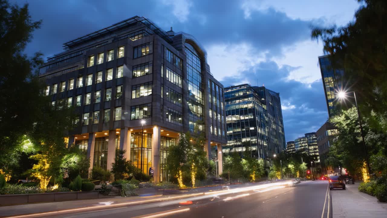Una serena tarde urbana: edificios modernos iluminados por farolas y vegetación circundante en un paisaje urbano capturado al anochecer