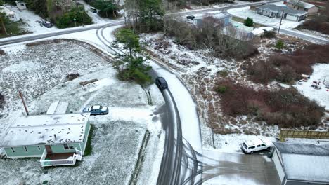 drone shot of car driving through a snow covered neighborhood