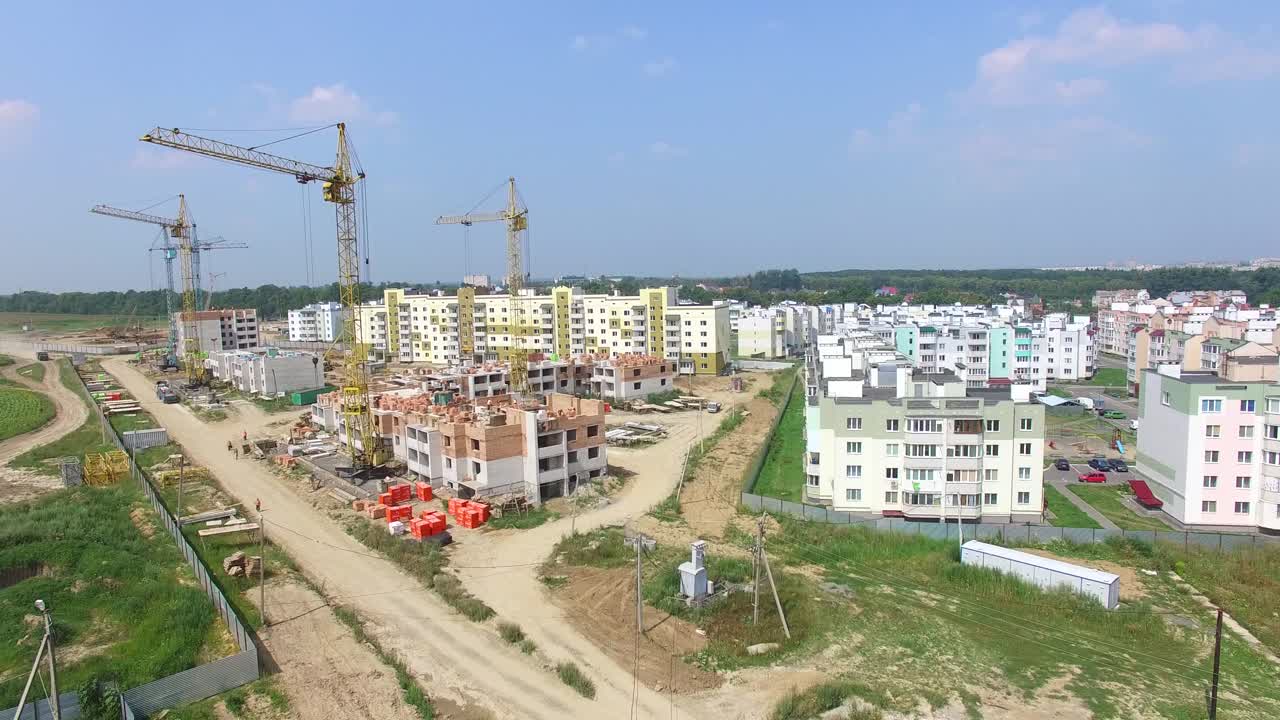 builders are working on the construction of modern high-rise buildings on the background of the city. Aerial view