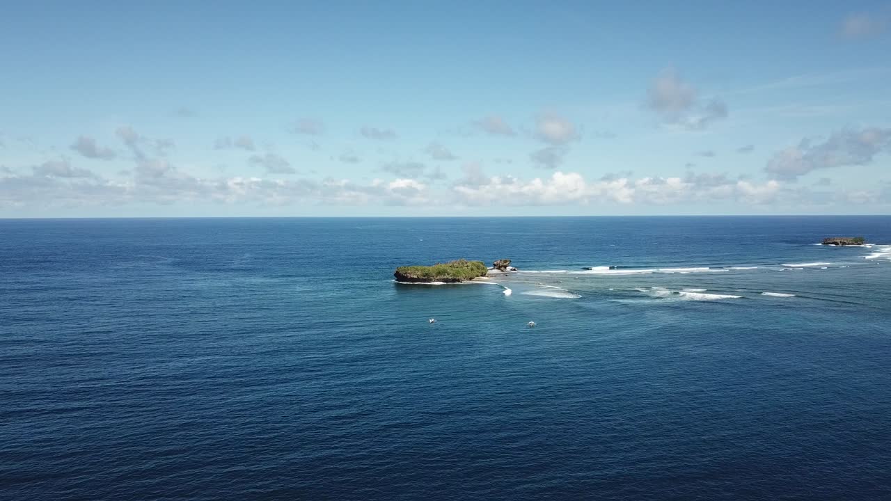 una foto de pájaro de barcos y surfistas dirigiéndose a rock island en la isla de siargao