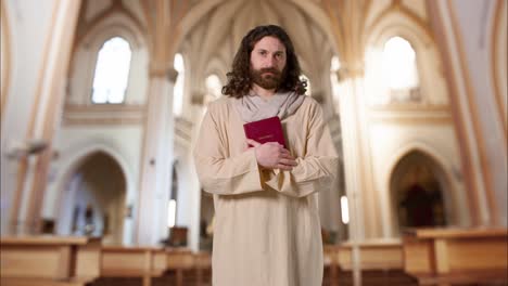 portrait of man wearing robes with long hair and beard representing figure of jesus christ holding bible in church