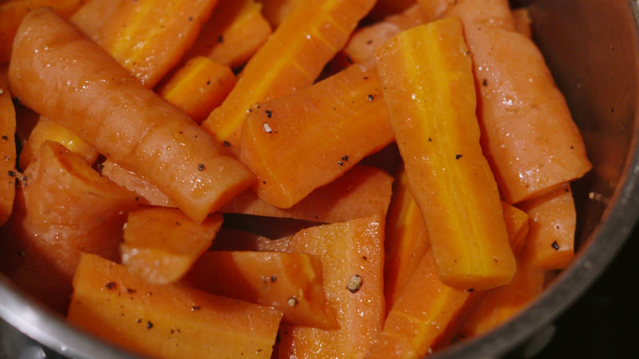 Carrots in a Pan Par Boiled and Covered in Butter and Cracked Black Pepper Ready to Roast for Family Dinner Feast. Healthy Vegetables for Balanced Diet 4K.