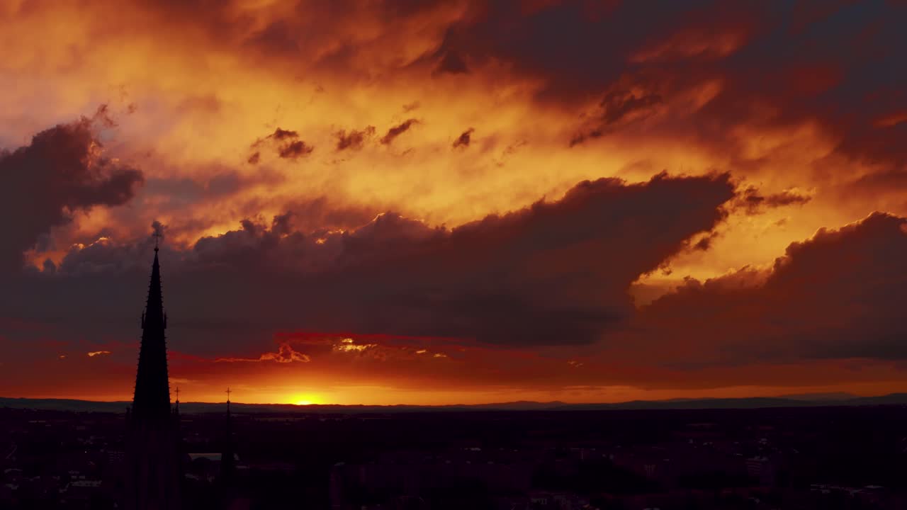 Orange Sunset Sky And Dark Clouds Over City Landscape. - Drone Shot Tilt-Down
