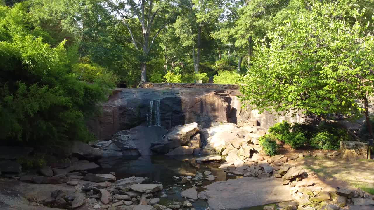 Uma tomada por drone orbitando uma cachoeira em um parque.