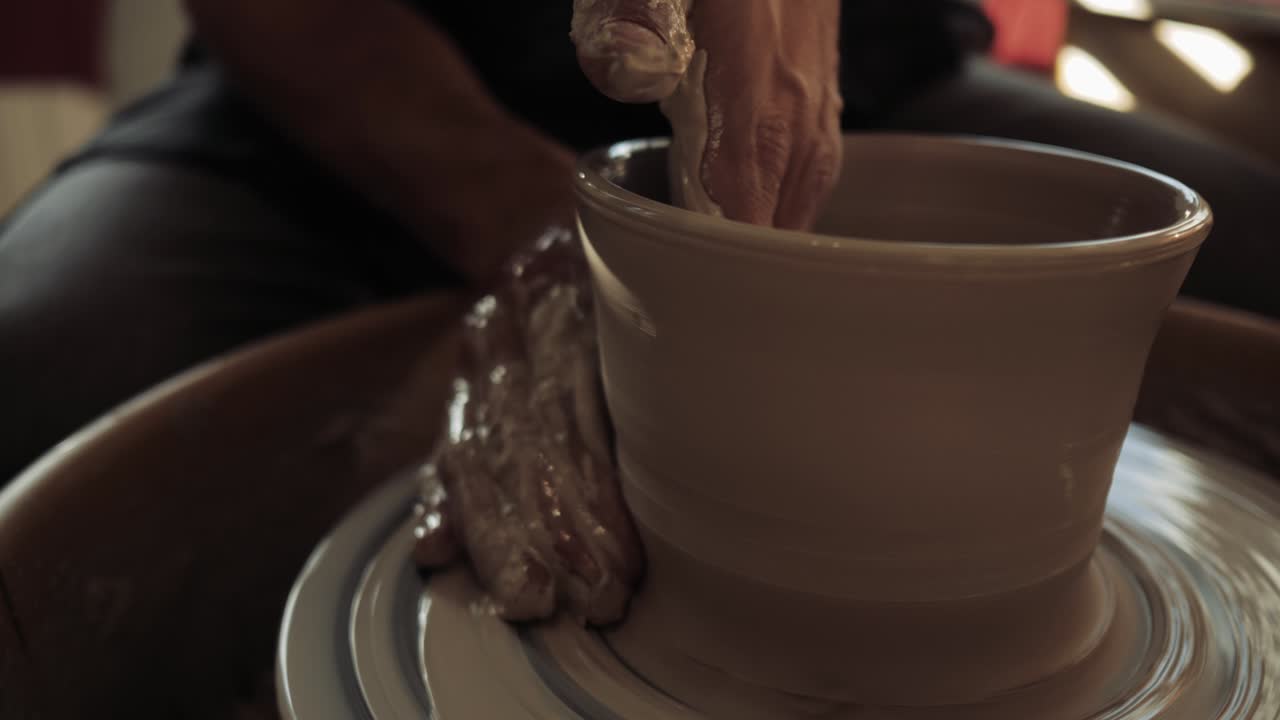 젊은 남성 도자기의 손은 도자기의 바에 일하고 도자기를 만들고 있습니다.
