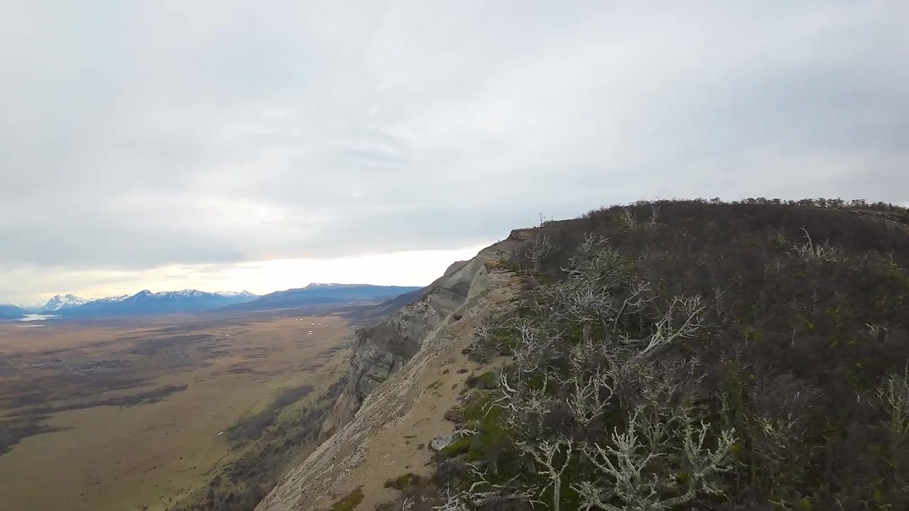Drone FPV escala os penhascos rochosos e em camadas do Cerro Dorotea, com vista para o vale perto de Puerto Natales, Região de Magalhães, Patagônia Chilena