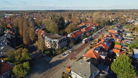 jib up of beautiful small town in the netherlands with cyclist and a car on the calm road