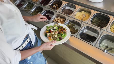 mujer en un bar de ensaladas