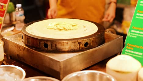 preparing banana crepes at vibrant street market in thailand