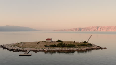 cinematic aerial shot of a church on a tiny island in the middle of the sea during sunrise, blue hour, seagulls flying around, sveti marin chapel, novi vinodolski, croatia, summer, travel destination