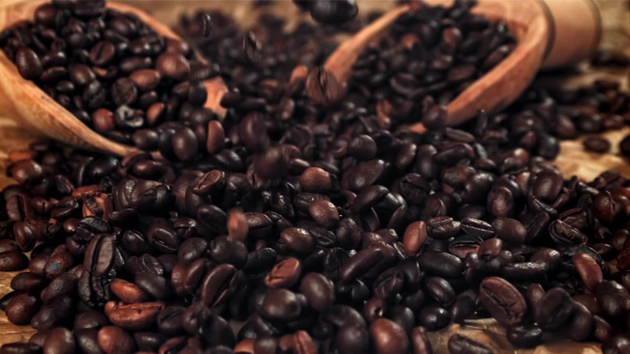 Movimento rallentato di chicchi di caffè tostati che cadono.