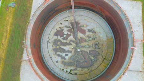 top view of petroleum storage tank with rusty roof floating on surface of stored liquid