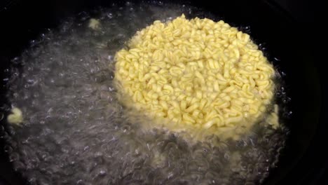 closeup boil circular noodles in boiling water.