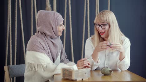 two women friends enjoying tea in a cafe