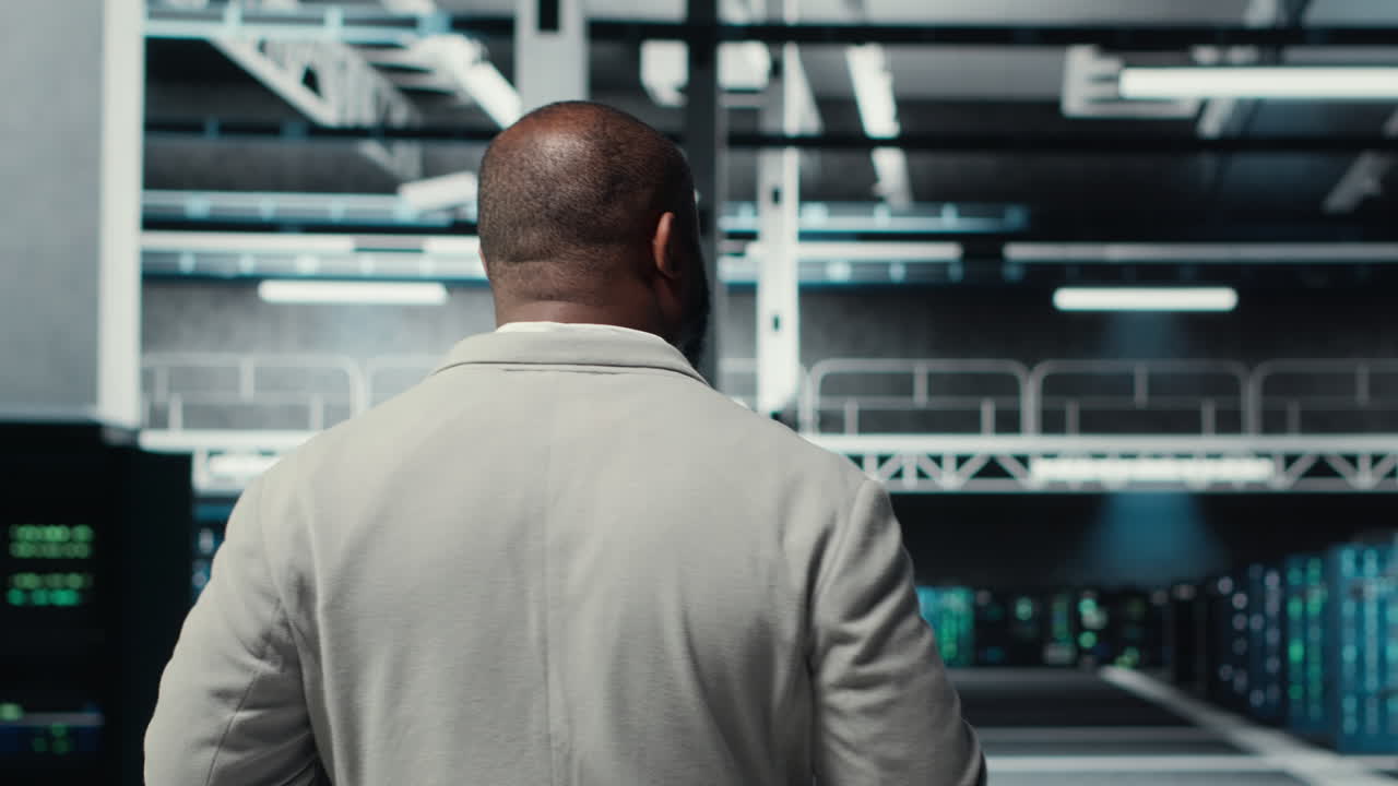 Vertical video Admin walking in high tech data center facility, checking equipment
