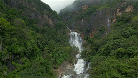 rising establishing aerial drone shot of ravana falls on misty day in ella sri lanka