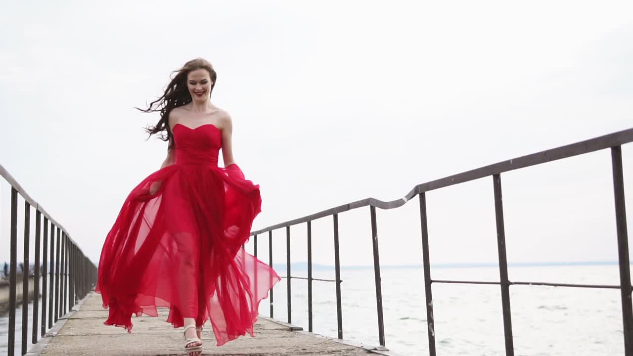Woman in Red Dress Walking on a Pier