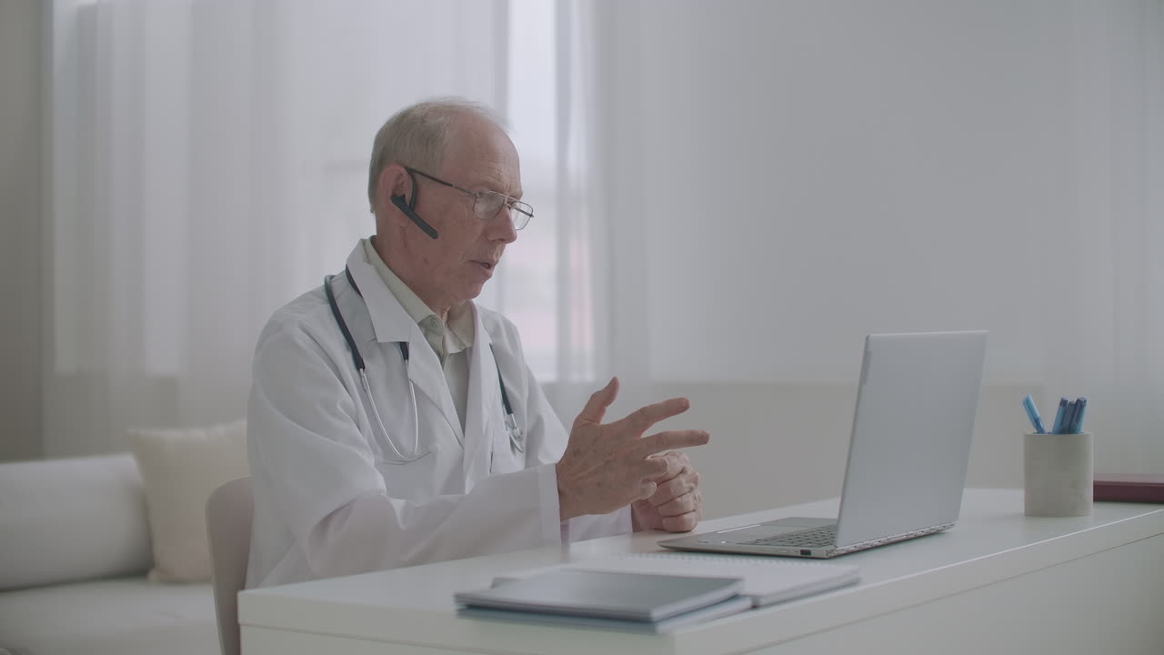 anziano esperto professore di medicina sta tenendo lezioni online seduto in ufficio insegnando agli studenti