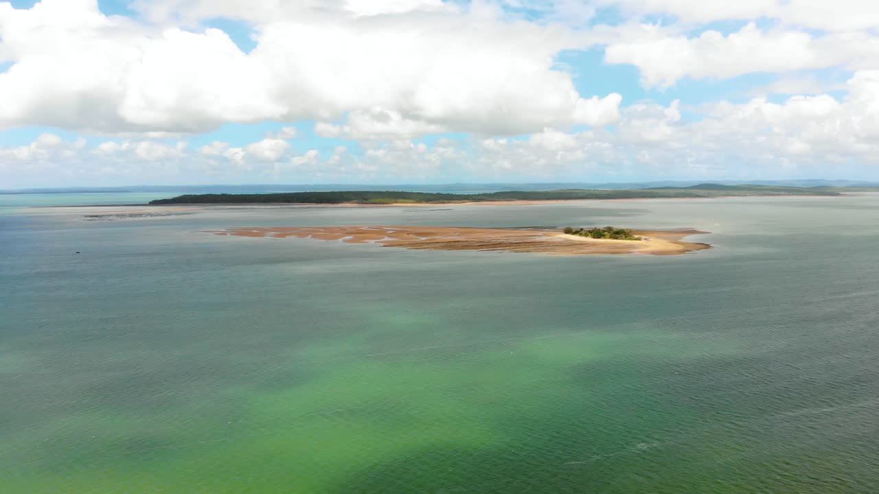 아름답고 완벽한 푸른 하늘 아래 여러 개의 작은 섬 옆에 있는 작은 모래 섬을 향해 화려한 열대 바다를 가로질러 선형 추진