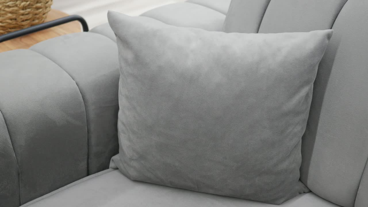 sofá gris con almohada de lanzamiento en una sala de estar moderna