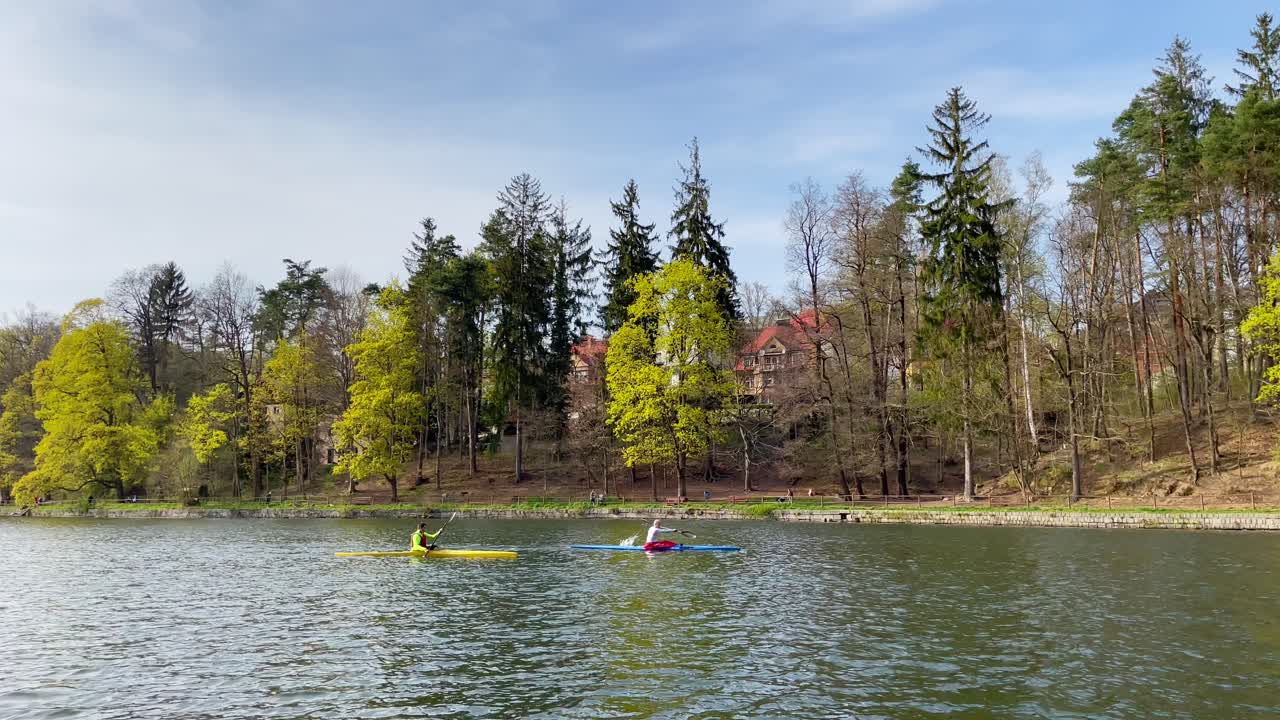 dos kayakistas en kayak en presa o estanque en liberec, república checa, vista de gran angular, día soleado