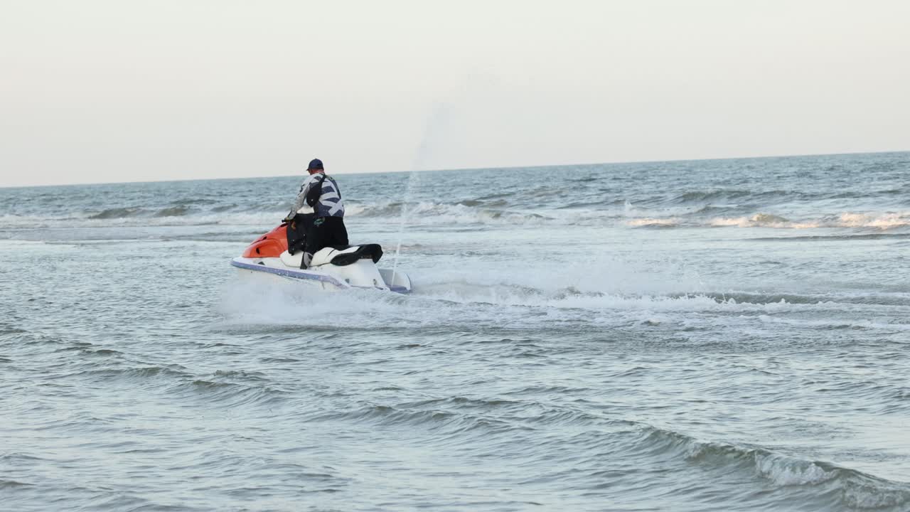 바다의 물결 을 가로질러 제트 스키 를 타고 있는 사람