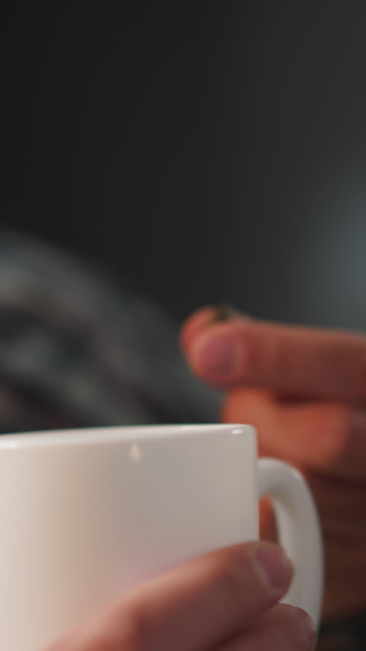 женщина дает капсулу бородатому мужу с заболеваниями сердца на размытом фоне. мужчина принимает лекарства, пьет воду из белой чашки дома вблизи