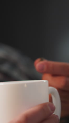 woman gives capsule to bearded husband with heart diseases on blurred background. man takes medication drinking water from white cup at home closeup