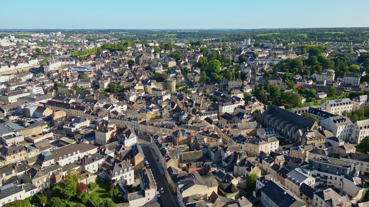 Drone ascending view of Laval, following the main street with churches, historic buildings, and cityscape in the distance