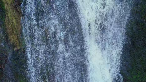 Aerial-drone-footage-of-a-tall-rocky-waterfall-in-the-Yorkshire-Dales,-Pennies