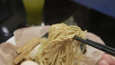 Mann-Verwendet-Chocpstick-Pick-Ramen-Japanische-Nudeln-Essfertig