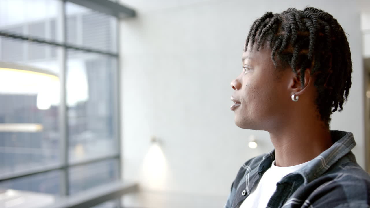 Contemplating, person looking out window in modern office environment, copy space