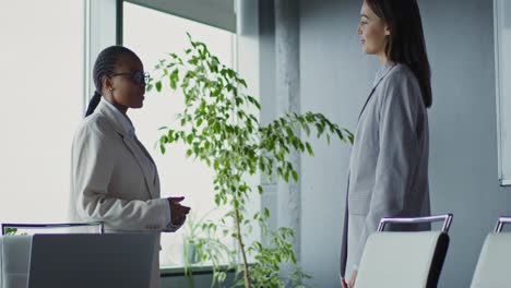 businesswomen shaking hands in modern office