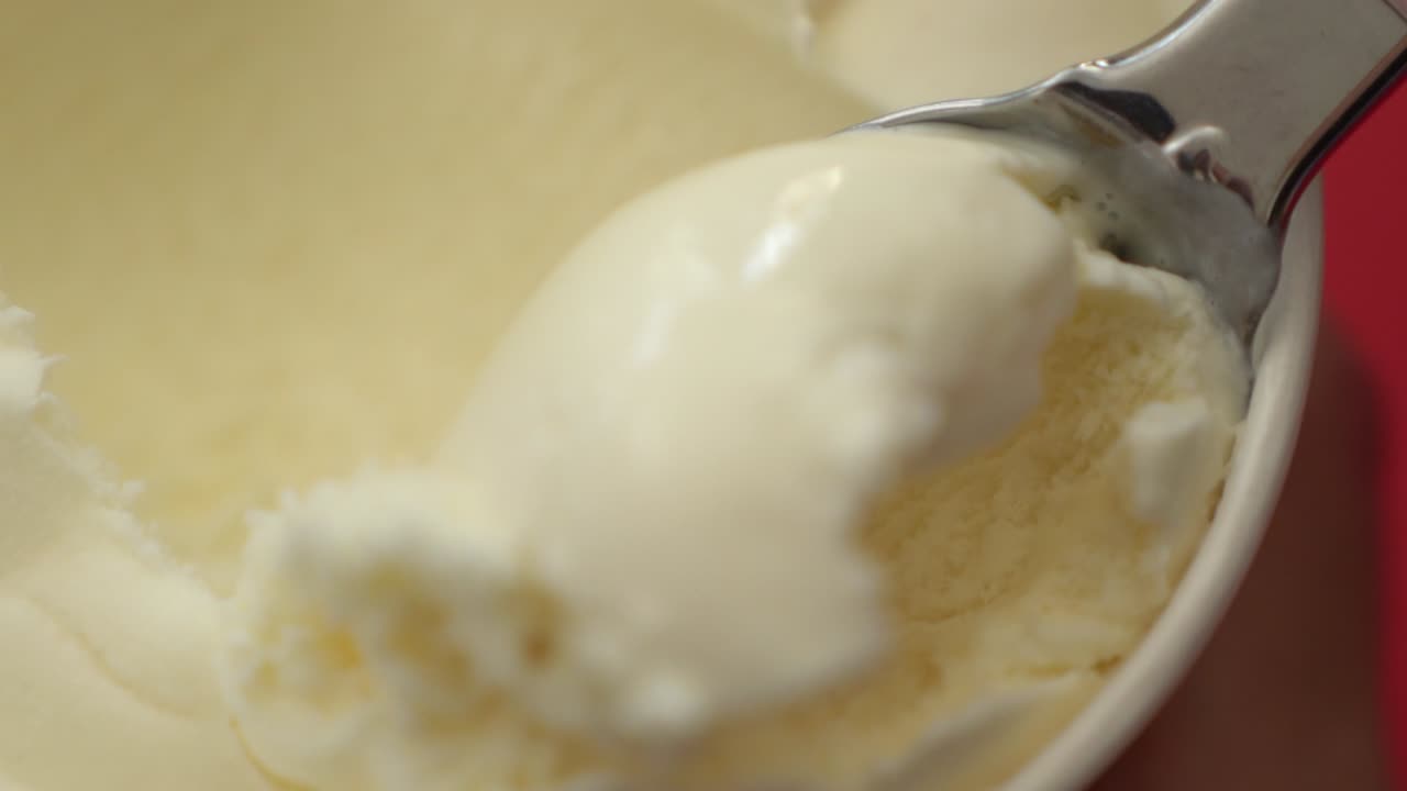 Slowmotion nærbillede af vaniljeis, der skovles op
