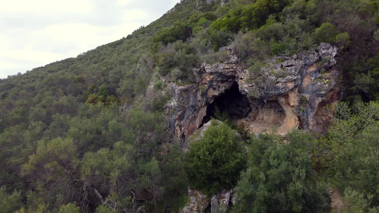 1 millón de dólares de largo vista aérea de imágenes de drones de vuelo de una gran cueva de explorador en una montaña en la naturaleza de aventura salvaje corfú en grecia