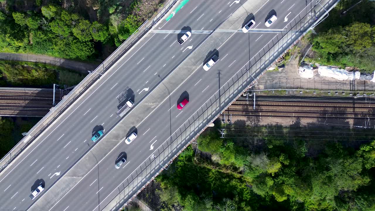 Drone aerial landscape of car vehicles driving over bridge on road highway with railway tracks train line in Tuggerah Wyong Central Coast Australia transport travel