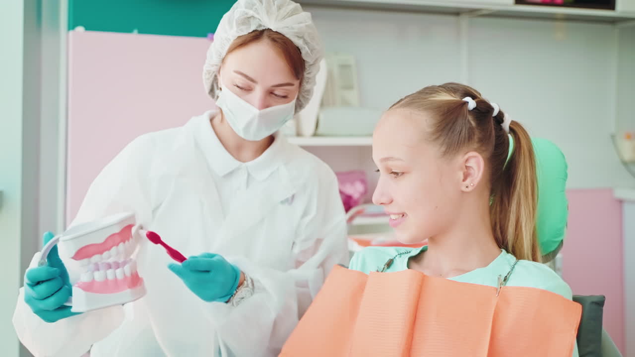 Dentist teaching a girl about oral hygiene