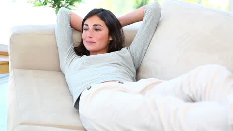 a woman lying on the couch and smiling