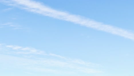 clouds forming and dissipating in a blue sky