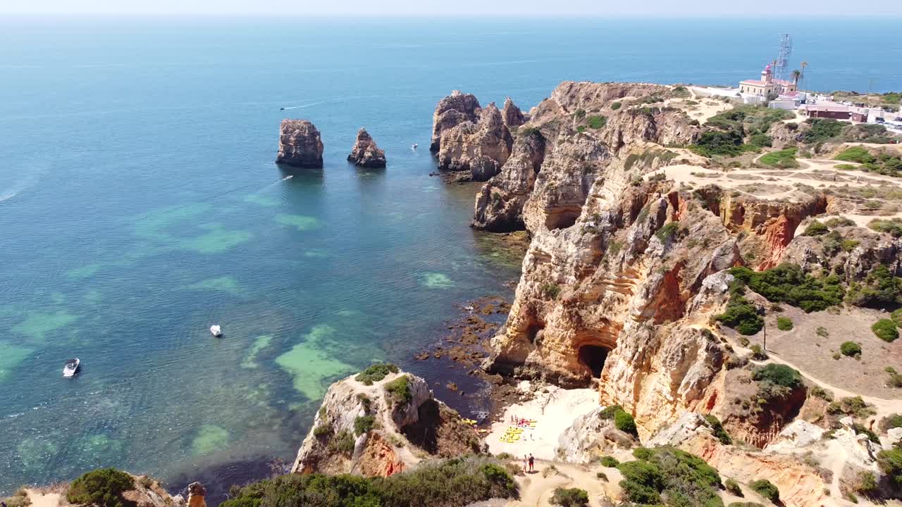 ponta da piedade, lagos, algarve, portugal - 산책로, 바위 절벽, 숨겨진 해변, 보트, 카약, 맑은 바다가 있는 해안선의 공중 드론 전망