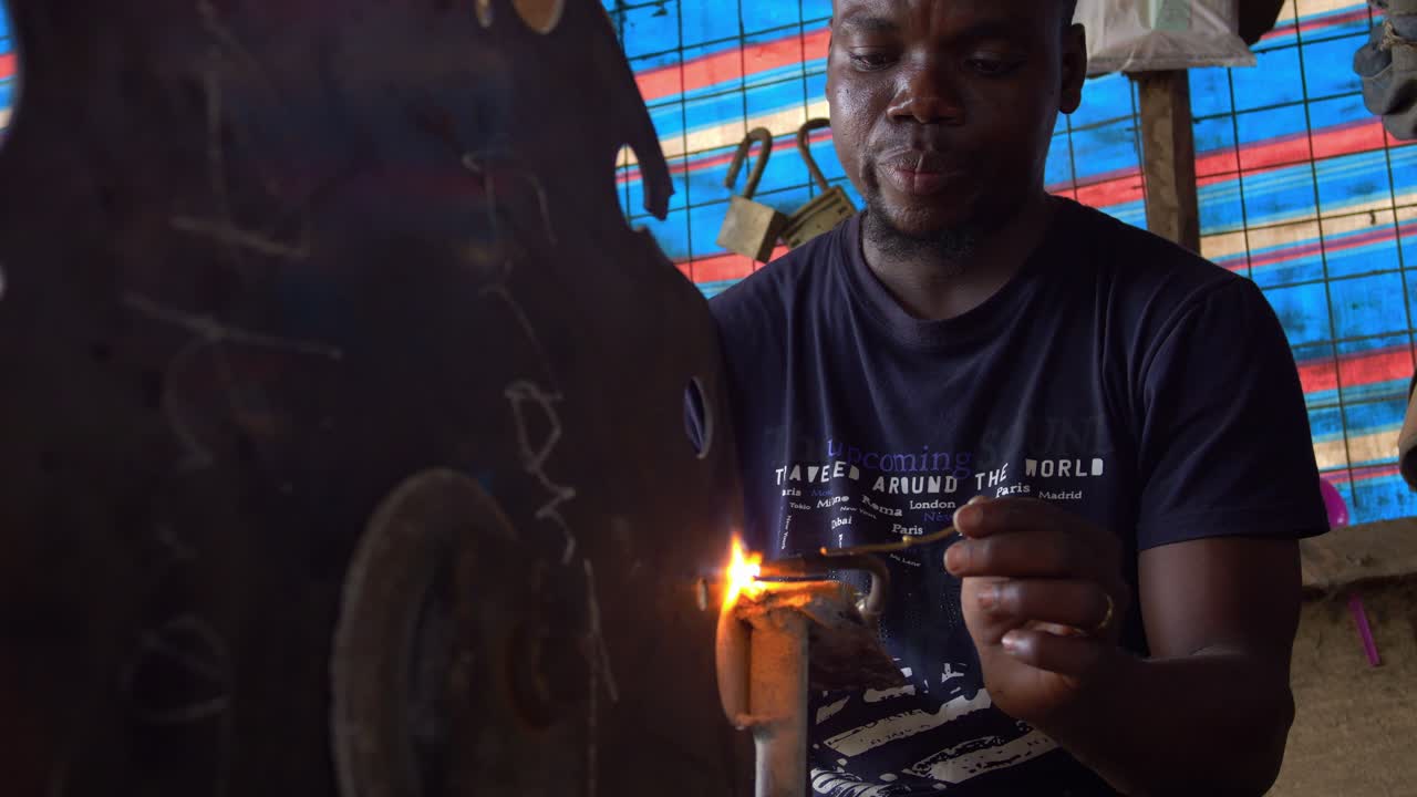 아프리카 의 실버 스미트 는 실내 에서 수리 가게 에서 금속 을 녹이는 일 을 하고 있다