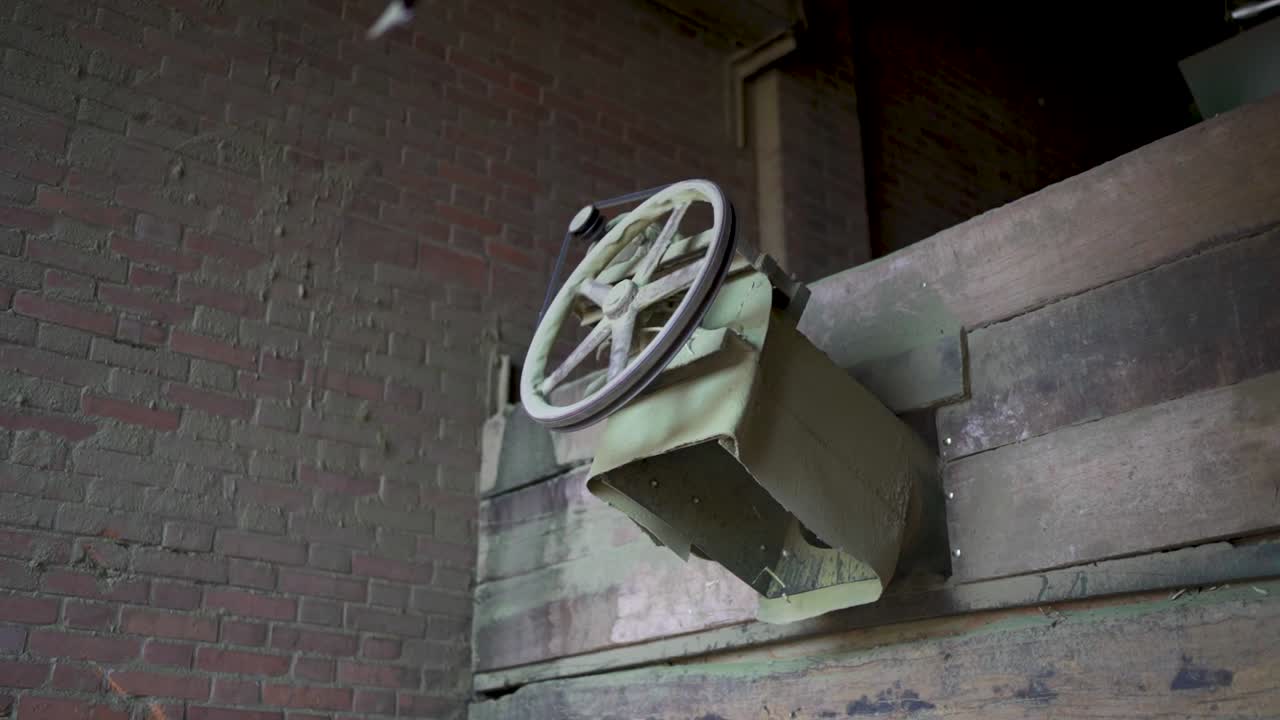 Old industrial pulley mechanism in work used for processing yerba mate leaves in a traditional factory in Misiones, Argentina